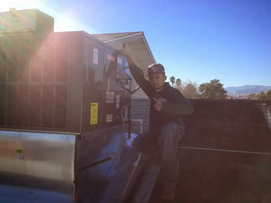 HVAC technician performing Air Duct Repair on a rooftop unit in Columbia City
